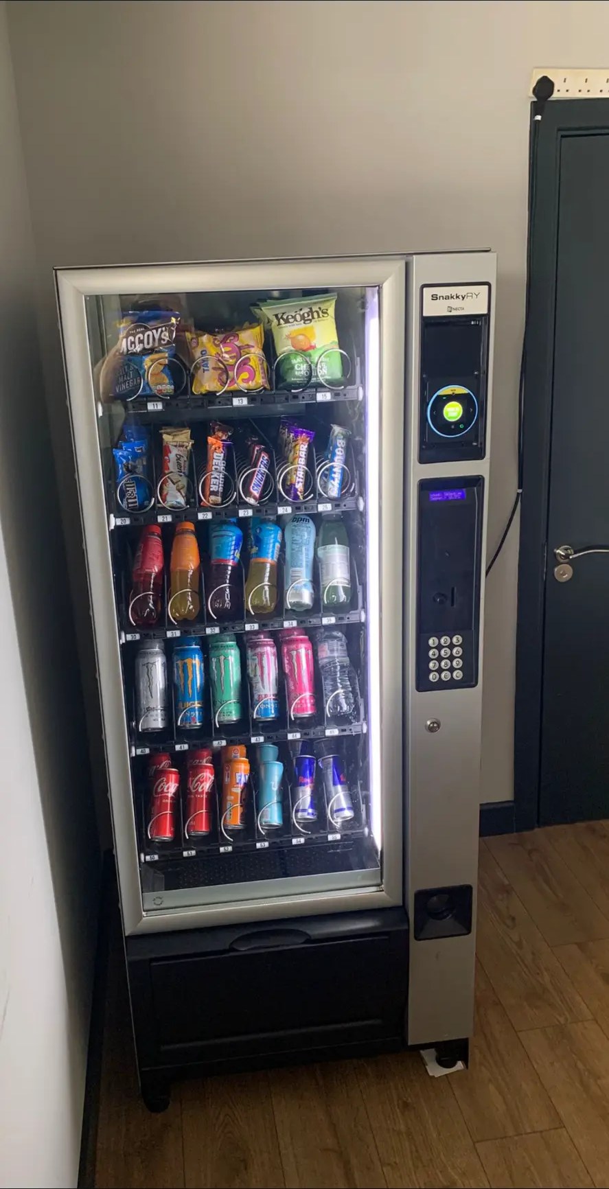 Right Now Solutions glass-front vending machine stocked with snacks and chilled drinks in a waiting area