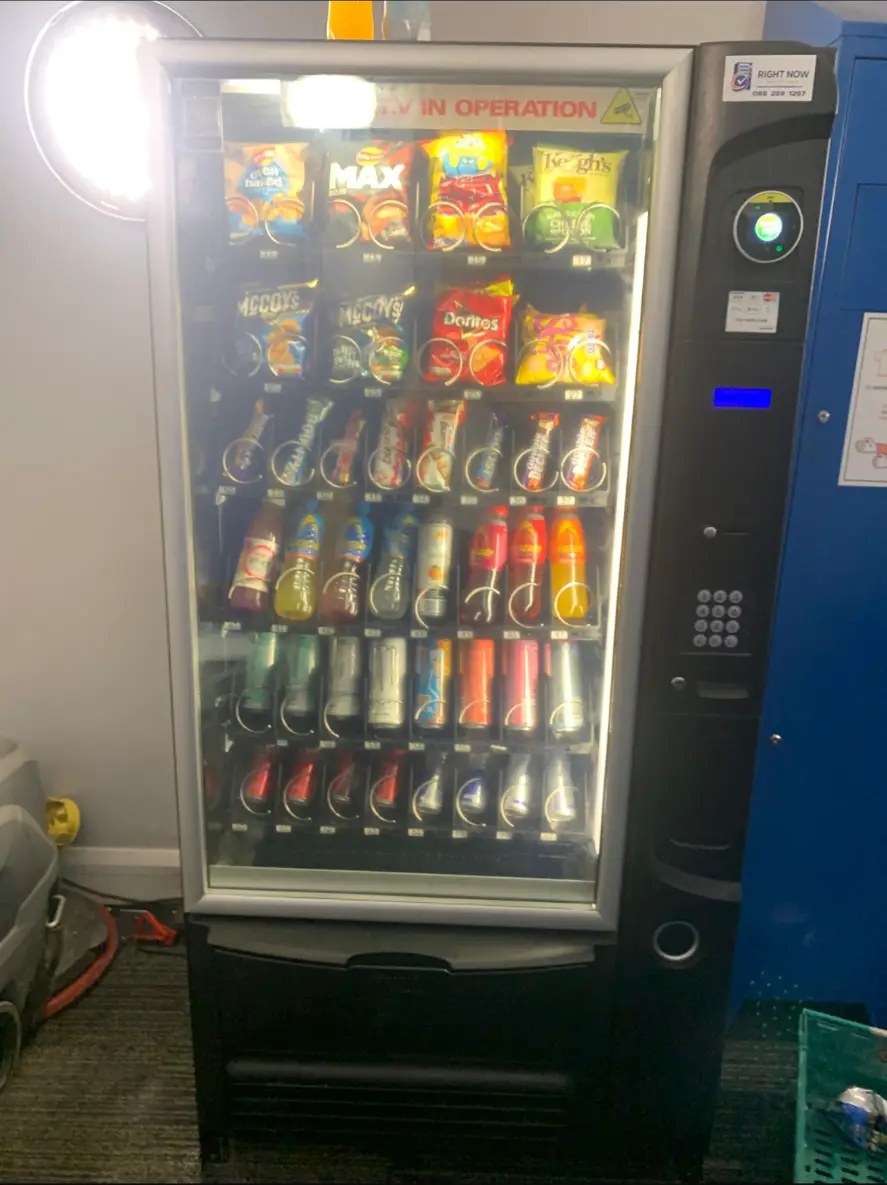 Vending machine stocked with snacks and drinks in a staff room